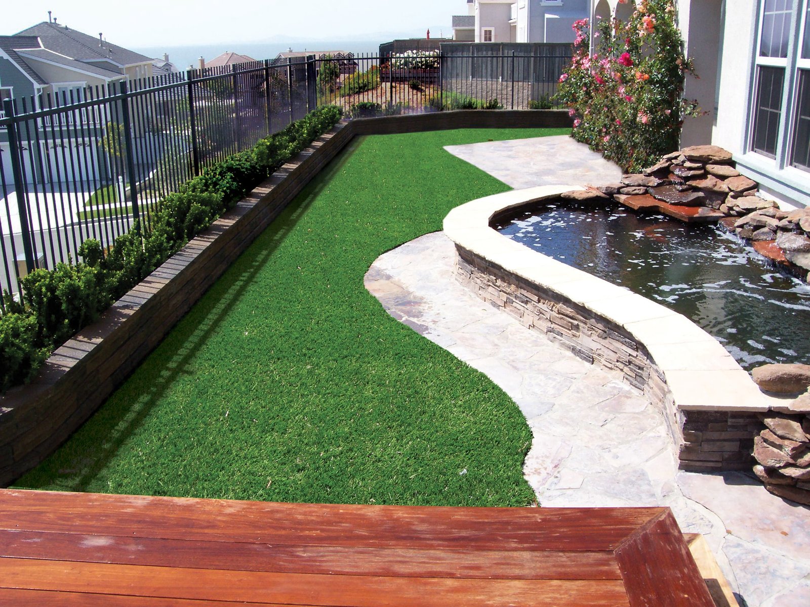 Hillside backyard with koi pond and turf